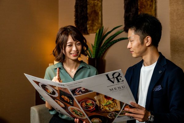 ルームサービスのメニューを選ぶカップル